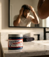 Blue Magic Pressing Oil - pot sur le lavabo, homme aux cheveux bouclés devant le miroir