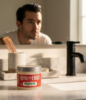 Royal Crown Pomade - pot sur le lavabo, homme avec un slick back devant le miroir